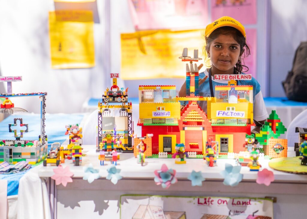 A child from the Dharwad team posing with her LEGO model